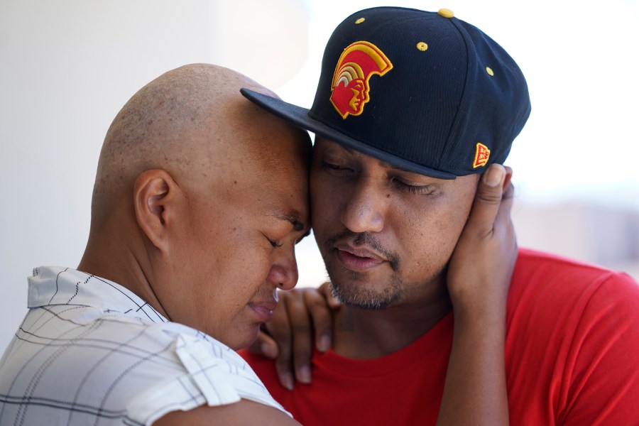 FILE - JP Mayoga, right, a chef at the Westin Maui, Kaanapali, and his wife, Makalea Ahhee, hug on their balcony at the hotel and resort, Sunday, Aug. 13, 2023, near Lahaina, Hawaii. About 200 employees were living there with their families. (AP Photo/Rick Bowmer, File)