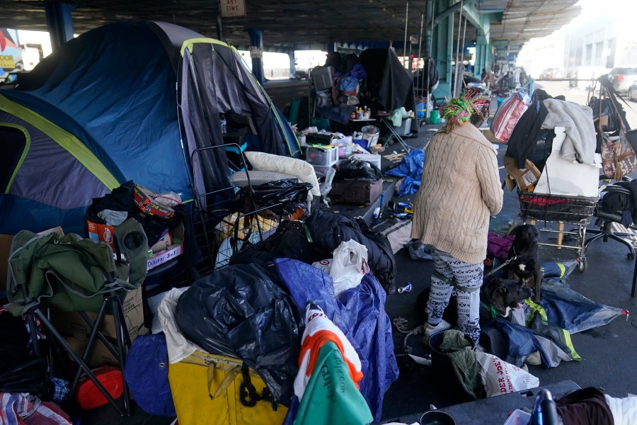 FILE - A woman gathers possessions to take before a homeless encampment was cleaned up in San Francisco, Aug. 29, 2023. The Supreme Court will hear its most significant case on homelessness in decades Monday, April 22, 2024, as record numbers of people in America are without a permanent place to live. The justices will consider a challenge to rulings from a California-based federal appeals court that found punishing people for sleeping outside when shelter space is lacking amounts to unconstitutional cruel and unusual punishment. (AP Photo/Jeff Chiu, File)