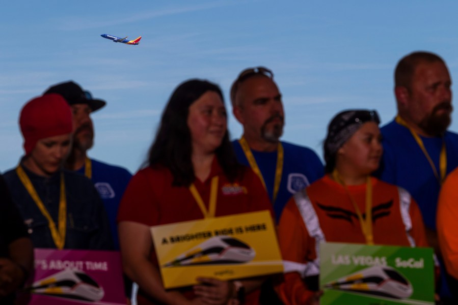 A plane takes off behind a groundbreaking for a high-speed passenger rail on Monday, April 22, 2024, in Las Vegas. A $12 billion high-speed passenger rail line between Las Vegas and the Los Angeles area has started construction. (AP Photo/Ty ONeil)