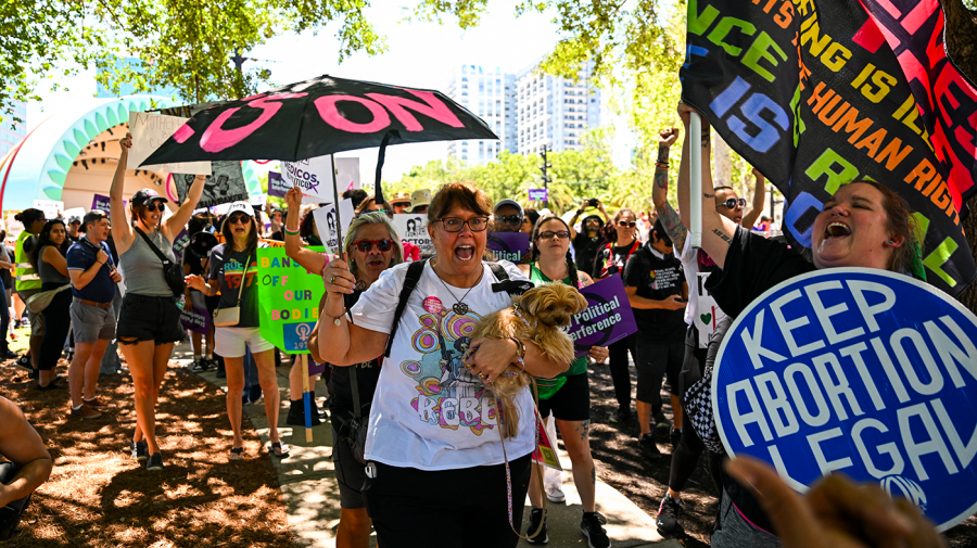 Abortion-rights activists demonstrate with brightly colored signs and props like painted umbrellas.