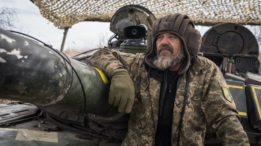 A soldier leans against equipment during a military training exercise.