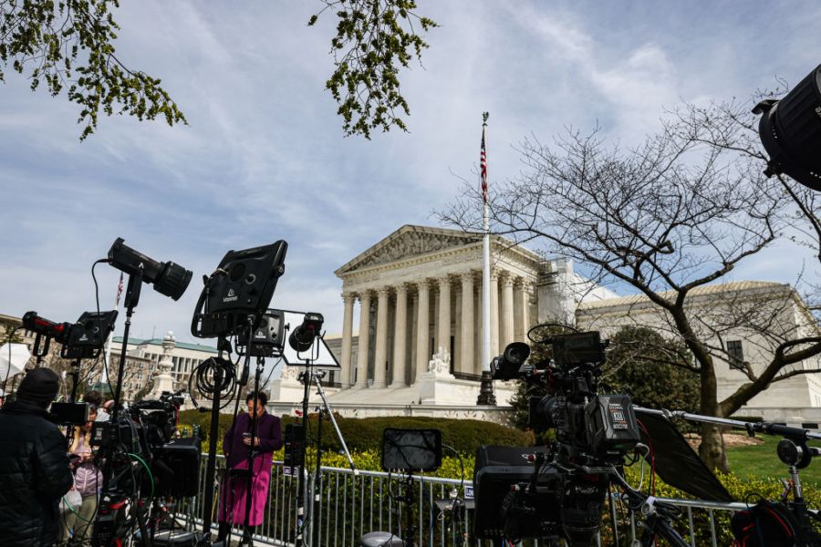 Cameras and lighting equipment are seen in front of the Supreme Court.