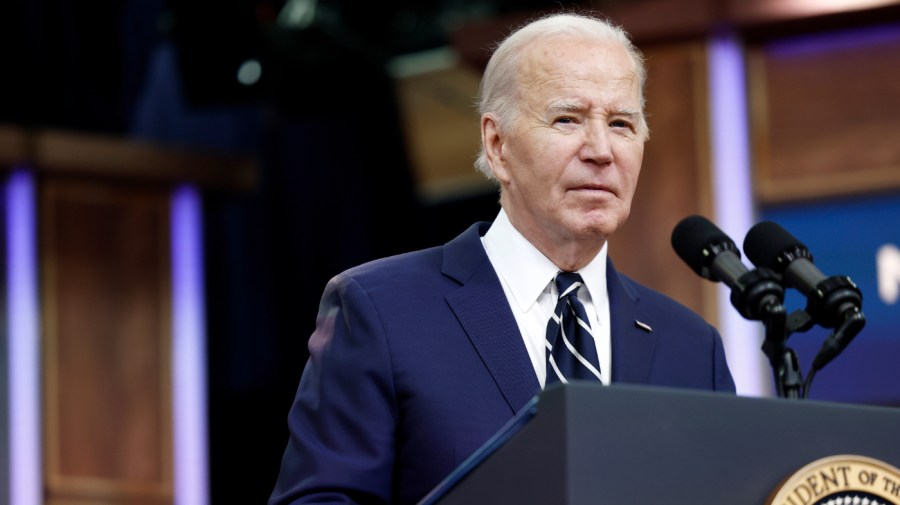 President Biden gives speaks into a microphone while delivering remarks.