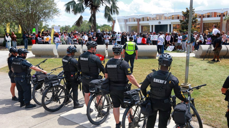 Orange County sheriffs with bicycles monitor a protest.