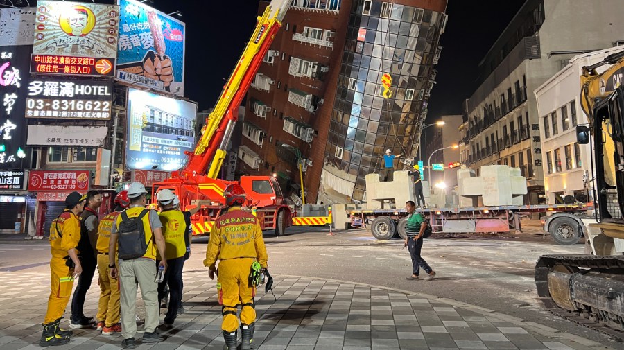 Rescue workers stand near the site of a leaning building in the aftermath of an earthquake in Hualien, Taiwan, on Wednesday, April 3, 2024. Taiwan's strongest earthquake in a quarter century rocked the island during the morning rush hour Wednesday.