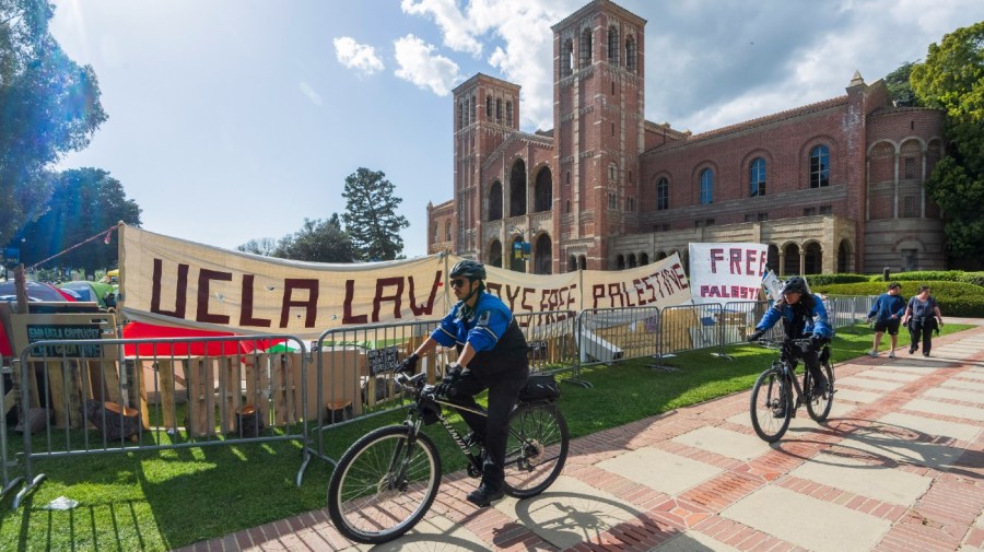 UCLA campus police cycle around the perimeter of a pro-Palestinian encampment on the UCLA campus Friday, April 26, 2024, in Los Angeles. As the death toll mounts in the war in Gaza and the humanitarian crisis worsens, protesters at universities across the country are demanding schools cut financial ties to Israel and divest from companies they say are enabling the conflict. (AP Photo/Damian Dovarganes)