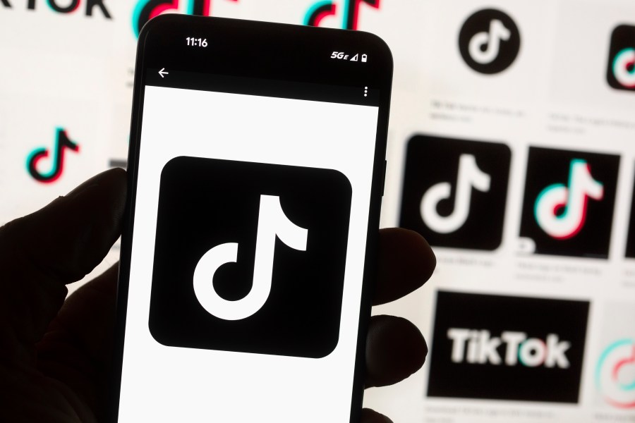 FILE - The TikTok logo is displayed on a mobile phone in front of a computer screen, Oct. 14, 2022, in Boston. On Tuesday, May 7, 2024, TikTok and its Chinese parent company ByteDance filed suit against the U.S. federal government to challenge a law that would force the sale of ByteDance's stake or face a ban, saying that the law is unconstitutional. (AP Photo/Michael Dwyer, File)