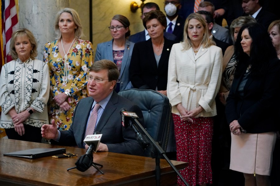 FILE - Mississippi Republican Gov. Tate Reeves is surrounded by legislative supporters after signing a bill to ban transgender athletes from competing on girls' or women's sports teams on March 11, 2021, at the state Capitol in Jackson, Miss. On Monday, April 29, 2024, Mississippi House and Senate negotiators quietly killed two bills that would have further restricted recognition of transgender people by limiting which bathrooms they could use in public buildings and by specifying that "there are only two sexes, and every individual is either male or female." (AP Photo/Rogelio V. Solis, File)