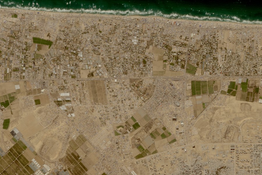 This image provided by Planet Labs PBC shows tent camps line the beach and fill empty lots outside the central Gaza city of Khan Younis, Friday, May 24, 2024, housing Palestinians who fled Israel's offensive in Rafah the past three weeks. (Planet Labs PBC via AP)