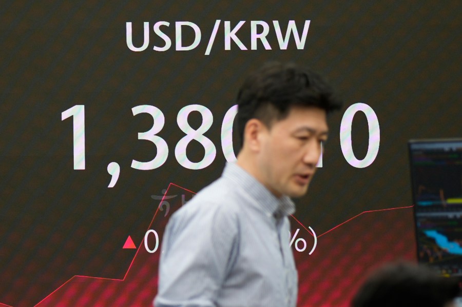 A currency trader walks by the screen showing the foreign exchange rate between U.S. dollar and South Korean won at a foreign exchange dealing room in Seoul, South Korea, Friday, May 31, 2024. (AP Photo/Lee Jin-man)