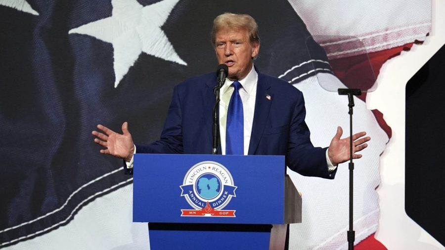 Former President Trump gestures while speaking at an event.