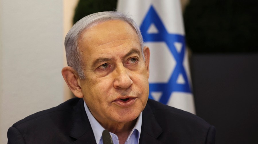 Israeli Prime Minister Benjamin Netanyahu is seen in front of an Israeli flag.