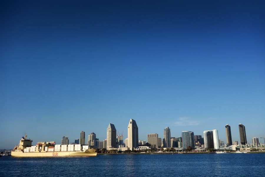 A ship passes through the bay in front of the San Diego skyline.