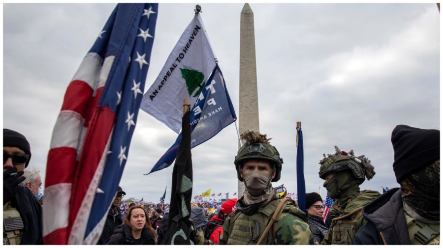 Pro-President Trump protesters dressed in gear carry flags as they gather in front of the U.S. Capitol.