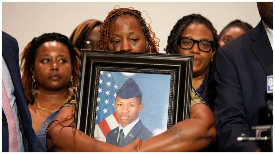 Mika Fortson, mother of Roger Fortson, a U.S. Navy airman, holds a photo of her son during a news conference with Attorney Ben Crump, Thursday, May 9, 2024, in Ft. Walton Beach, Fla. Fortson was shot and killed by police in his apartment on May 3, 2024. (AP Photo/Gerald Herbert)