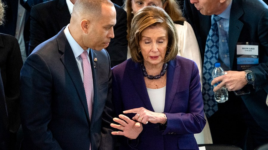 Minority Leader Hakeem Jeffries (D-N.Y.) listens to Rep. Nancy Pelosi (D-Calif.)