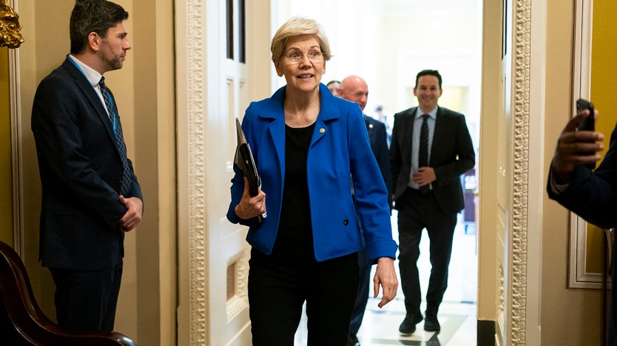 Senator Elizabeth Warren walks out of meeting.