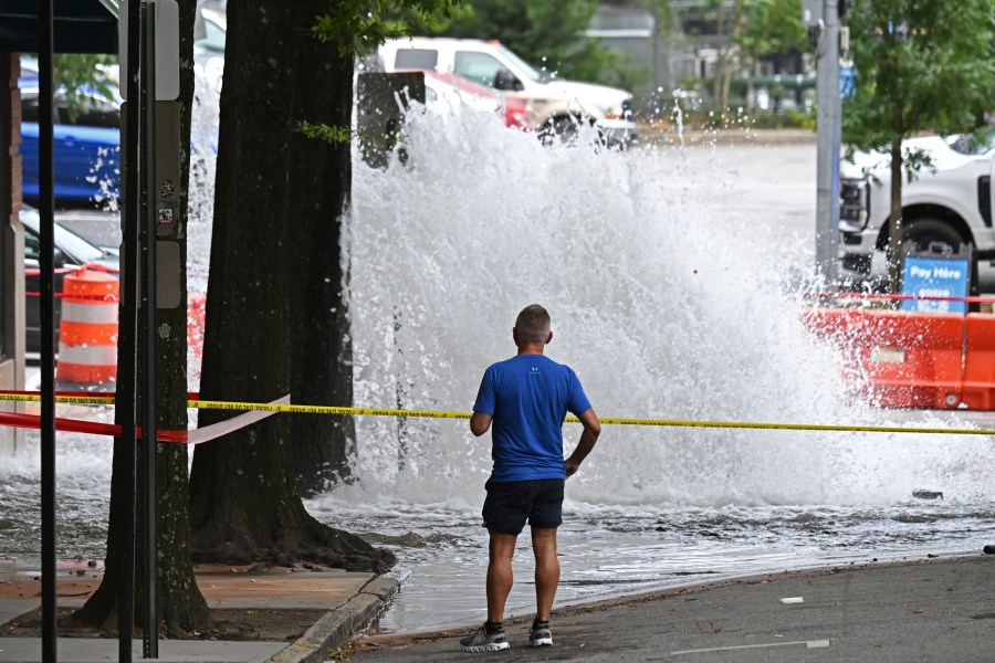 Joe Greene watches a water main break Saturday, June 1, 2024, in Atlanta. City officials were slowly repressuring the city's water system Saturday after corroding water pipes burst in downtown and Midtown, forcing many businesses and attractions to close and affecting water service in area homes. (Hyosub Shin/Atlanta Journal-Constitution via AP)