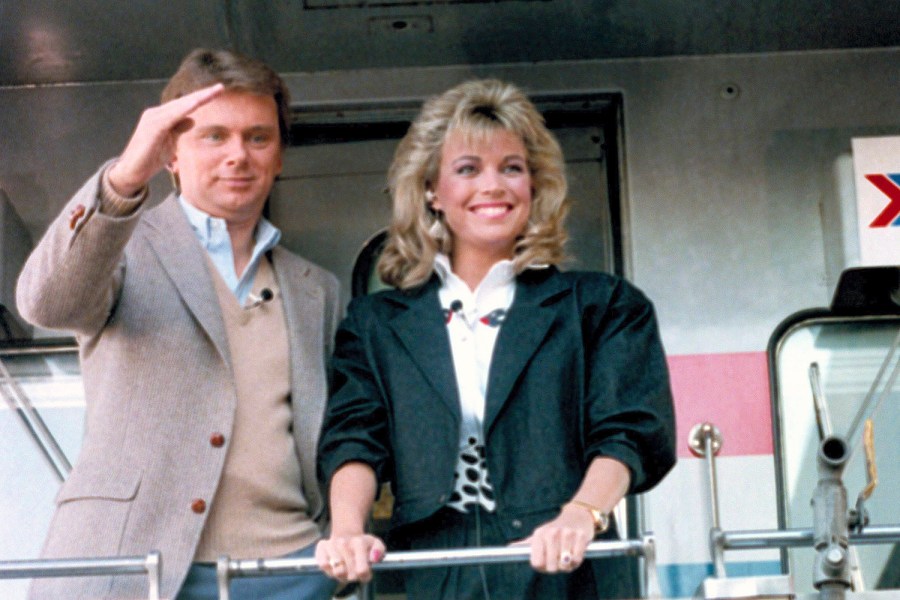 FILE - Pat Sajak, left, and Vanna White appear aboard the Wheel of Fortune Express in Miami on Feb. 12, 1987 to tour 33 cities from Miami to Washington, DC. (AP Photo/Judy Sloan, File)