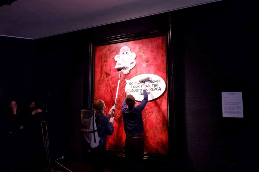 This photo released by Animal Rising shows activists pasting a picture of a character called Wallace, from the “Wallace and Gromit” comedy series, over a portrait of Britain's King Charles III at the Philip Mould Gallery in London, Tuesday June 11, 2024. Animal rights activists pasted a cartoon image over a portrait of King Charles III on Tuesday at a London art gallery, the latest in a series of incidents at U.K. museums as campaigners use vandalism to publicize their causes. (Animal Rising via AP)