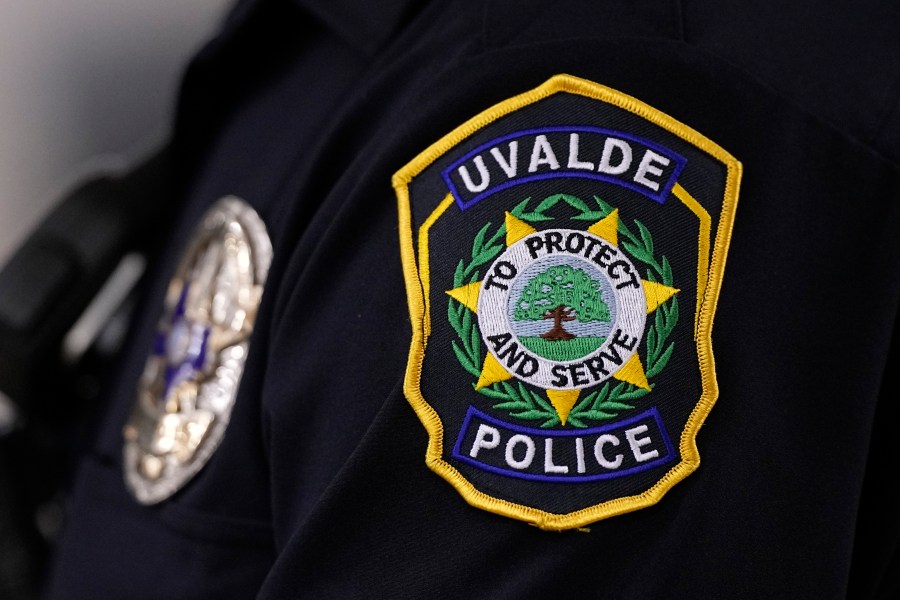 FILE - A Uvalde police officers patch and badge is seen as he stands watch over a special city council meeting in Uvalde, Texas, March 7, 2024. The former Uvalde schools police chief and another former officer have been indicted over their role in the slow police response to the 2022 massacre in a Texas elementary school that left 19 children and two teachers dead, according to multiple reports Thursday, June 27, 2024. (AP Photo/Eric Gay, File)