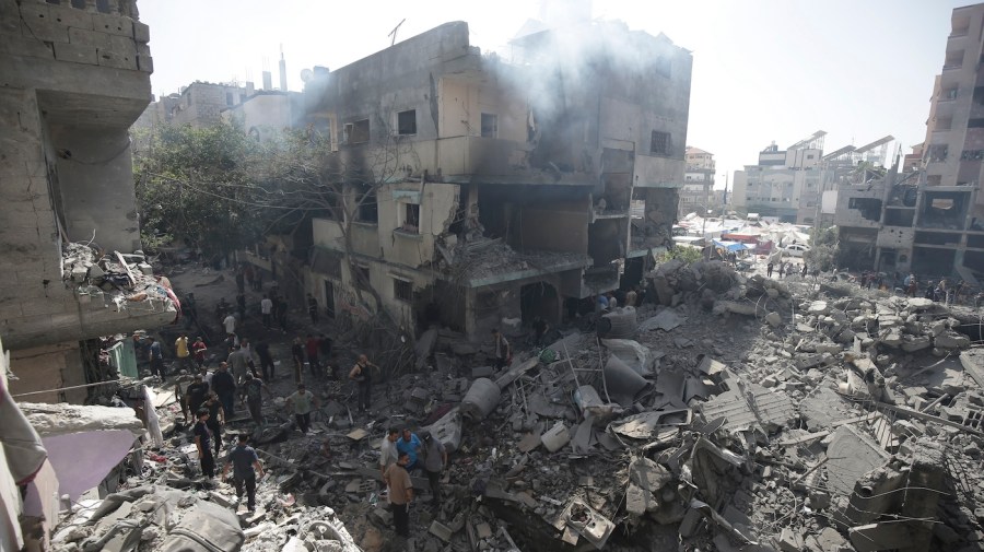 Palestinians look at the aftermath of the Israeli bombing in Nuseirat.