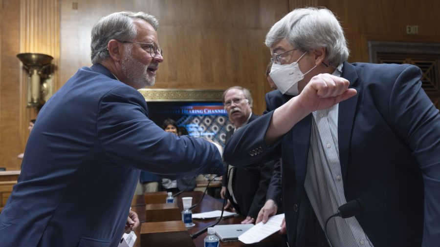 Sen. Gary Peters bumps elbows with Rutgers University professor Richard Ebright at a congressional hearing.