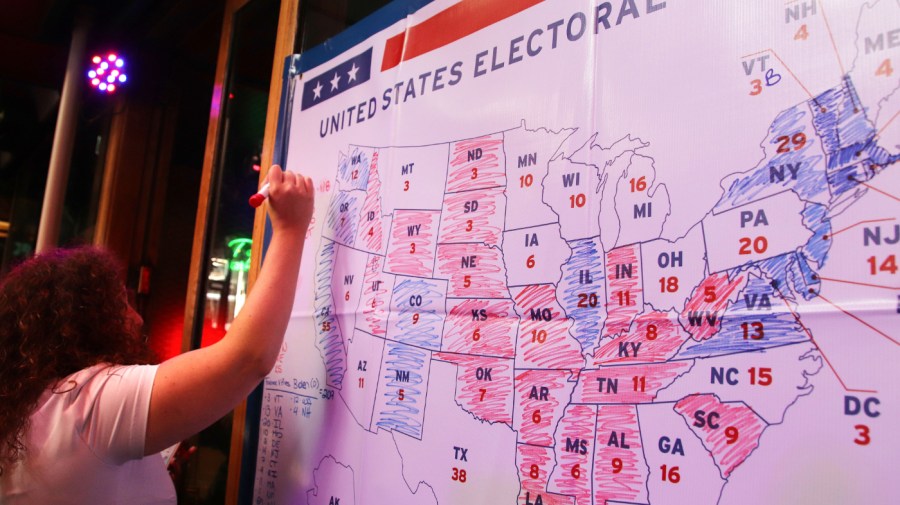 A woman prepares to color another state on the electoral college map in red for a Republican win at an event at Lulu Bar on November 04, 2020 in Wellington, New Zealand hosted by the United States Embassy and the NZ U.S Council to watch the results of the 2020 U.S election come through. After a record-breaking early voting turnout across the United States, Americans have headed to the polls on the last day to cast their vote for incumbent U.S. President Donald Trump or Democratic nominee Joe Biden in the 2020 presidential election. (Photo by Lynn Grieveson - Newsroom/Newsroom via Getty Images)