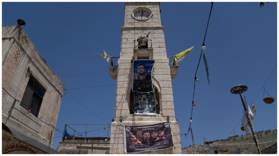 Posters show militants from the Lions' Den group on the side of a building.