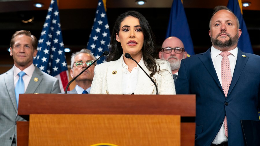 Representative Anna Luna speaks at a podium flanked by colleagues.