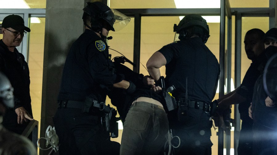 A pro-Palestinian demonstrator is taken into custody as University of California Police and California Highway Patrol officers face pro-Palestinian protesters outside Dodd Hall in the University of California at Los Angeles (UCLA) in Los Angeles, June 10, 2024. Several protesters were arrested by UCLA police following a new attempt to set up an encampment on the University campus.