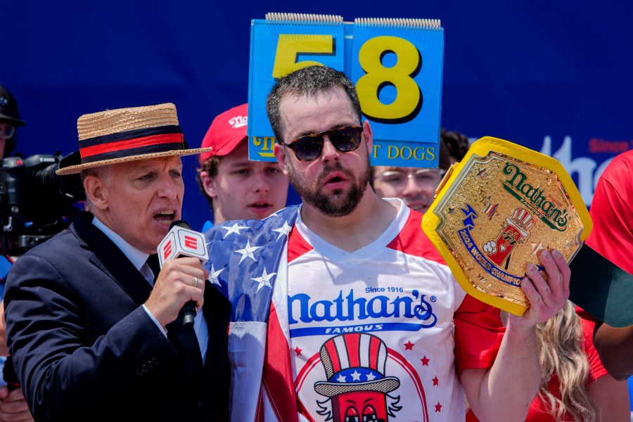 Patrick Bertoletti, right, reacts after winning the men's division in Nathan's Famous Fourth of July hot dog eating contest, Thursday, July 4, 2024, at Coney Island in the Brooklyn borough of New York. Bertoletti ate 58 hot dogs. (AP Photo/Julia Nikhinson)