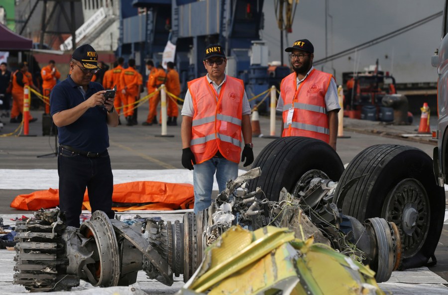 FILE - Officials inspect an engine recovered from the crashed Lion Air jet in Jakarta, Indonesia, Nov. 4, 2018. The brand new Boeing 737 MAX 8 jet plunged into the Java Sea just minutes after takeoff from Jakarta early on Oct. 29, killing all of its passengers on board. On Sunday, July 7, 2024, the Justice Department said Boeing has agreed to plead guilty to a criminal fraud charge stemming from two deadly crashes of 737 Max jetliners. (AP Photo/Achmad Ibrahim, File)