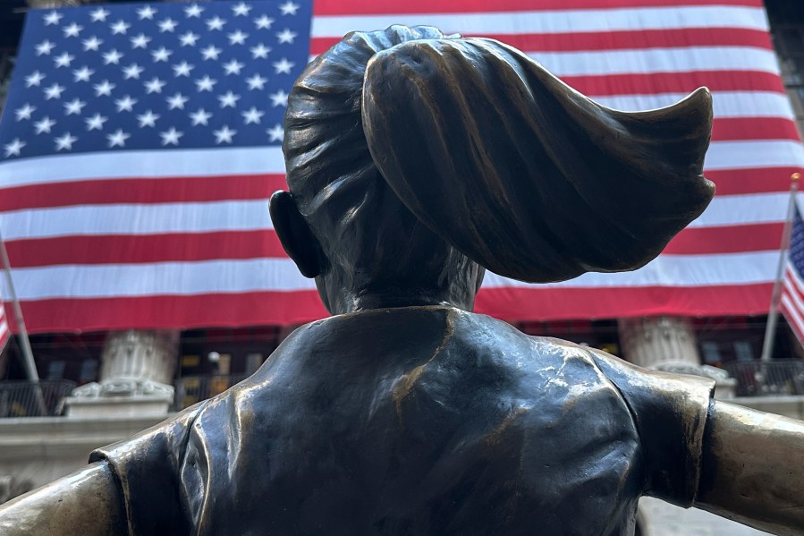 FILE - The Fearless Girl statues faces the New York Stock Exchange on July 2, 2024, in New York. Global stocks are mixed on Friday, July 12, 2024, with the Japanese yen losing some of its gains after the latest U.S. update on inflation bolstered Wall Street's belief that relief on interest rates may come as soon as September. (AP Photo/Peter Morgan, File)