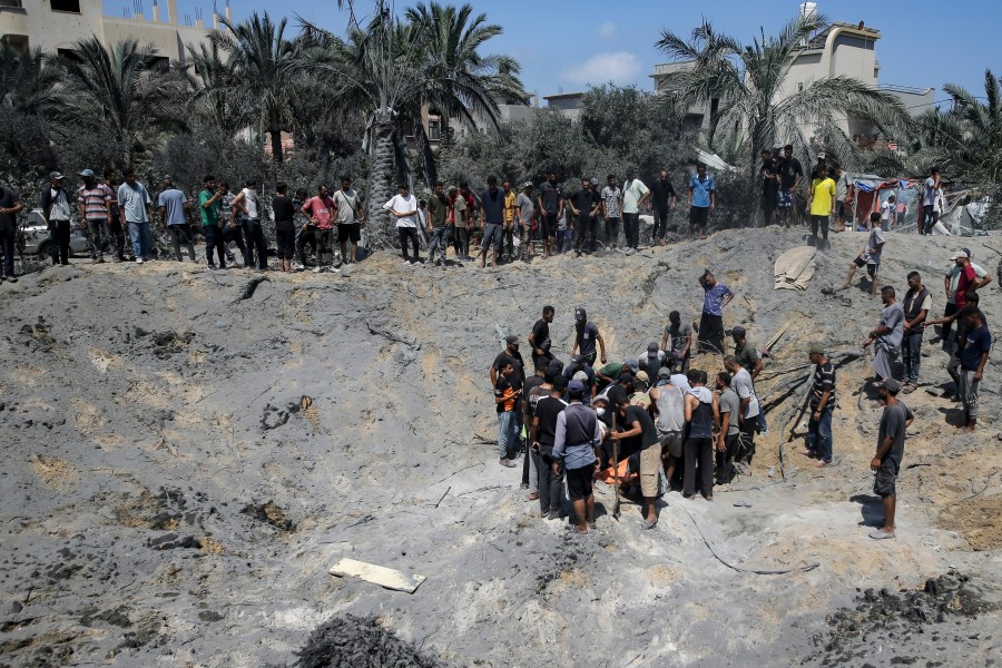 Palestinians search for bodies and survivors in a site hit by an Israeli bombardment on Khan Younis, southern Gaza Strip, Saturday, July 13, 2024. Israel said it targeted Hamas’ shadowy military commander in a massive strike Saturday in the crowded southern Gaza Strip that killed at least 71 people, according to local health officials. Hamas immediately rejected the claim that Mohammed Deif was in the area. (AP Photo/Jehad Alshrafi)