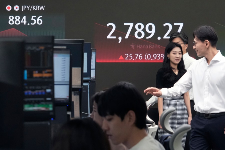 Currency traders pass by the screen showing the Korea Composite Stock Price Index (KOSPI) at the foreign exchange dealing room of the KEB Hana Bank headquarters in Seoul, South Korea, Tuesday, July 23, 2024. (AP Photo/Ahn Young-joon)