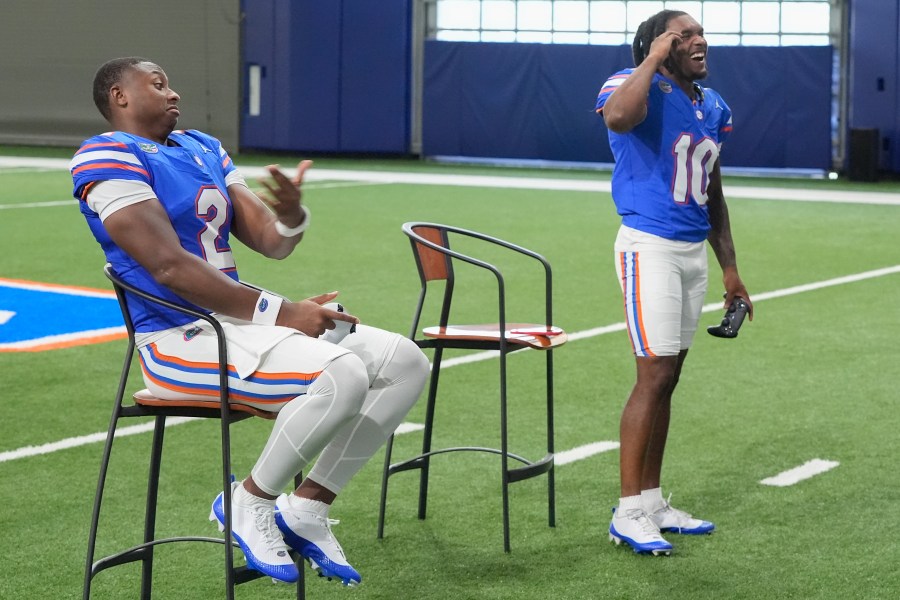 Florida wide receiver Tank Hawkins, right, and quarterback DJ Lagway (2) joke around as they play the EA Sports video game College Football 25 at the University of Florida, Tuesday, July 23, 2024, in Gainesville, Fla. (AP Photo/John Raoux)