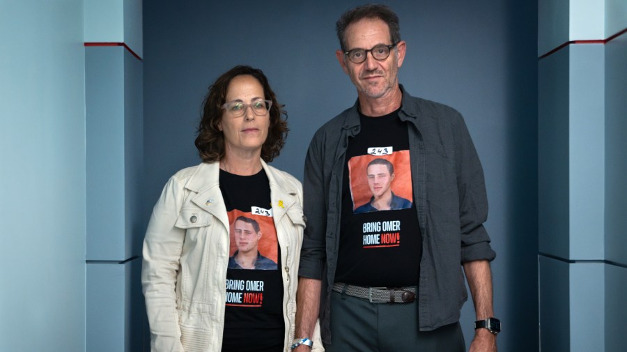 Orna Neutra and her husband Ronen Neutra, of Long Island, N.Y., whose son Omer Neutra, 22, is being held hostage by Hamas in Gaza, hold hands while posing for a portrait Wednesday, June 5, 2024, in Washington. The couple wears tape with the number of days that their son has been hostage.