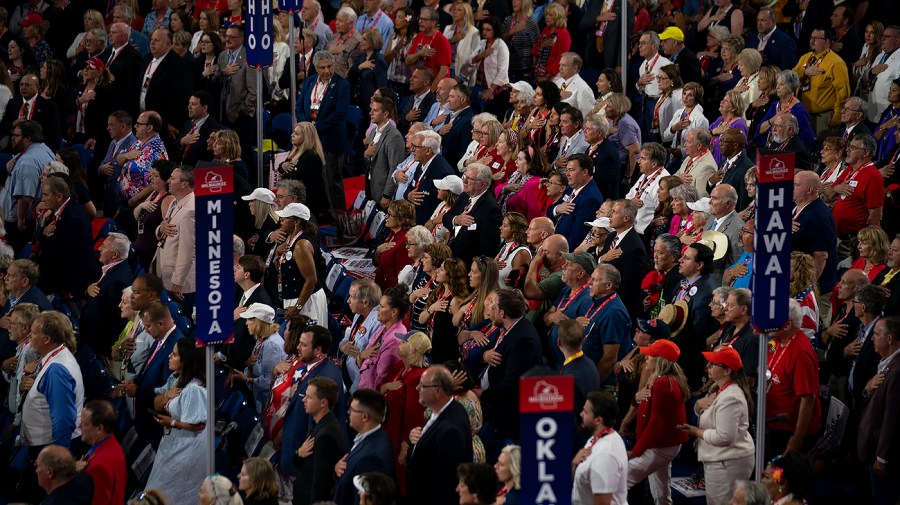 Delegates stand for the Pledge of Allegiance during the Republican National Convention