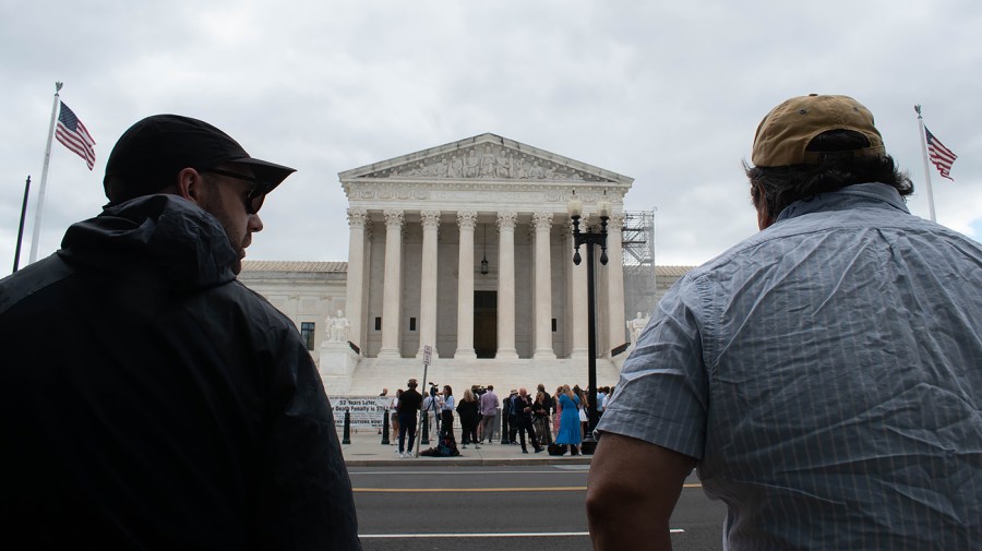 People wait outside the Supreme Court.