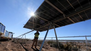 A worker secures mounting straps as construction continues with solar panel installation at the Gemini solar project in Southern Nevada Las Vegas, NV. (Brian van der Brug/Los Angeles Times via Getty Images)