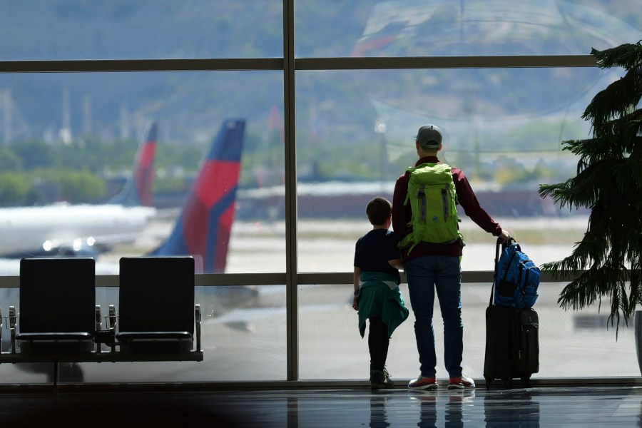 FILE - Travelers pass through Salt Lake City International Airport on May 24, 2024, in Salt Lake City. On Thursday, Aug. 1, 2024, Transportation Secretary Pete Buttigieg is expected to announce a new rule that would require airlines to do everything possible to ensure parents can sit with young children on flights. (AP Photo/Rick Bowmer, File)