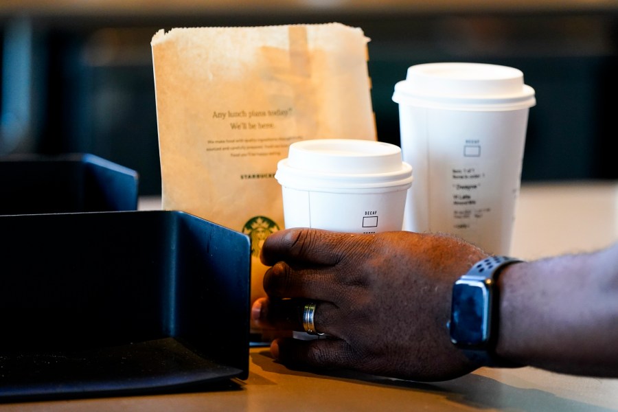 FILE - A customer picks up a drink at a Starbucks on June 28, 2023, in Seattle.(AP Photo/Lindsey Wasson, File)