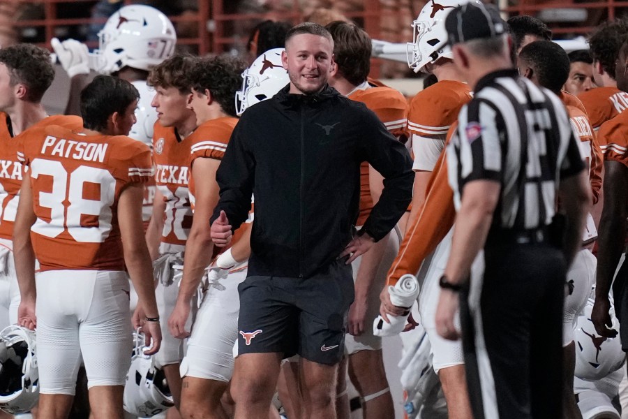 Texas quarterback Quinn Ewers, center, stands on the sidelines in street cloths after he was injured during the second half of an NCAA college football game against UTSA in Austin, Texas, Saturday, Sept. 14, 2024. (AP Photo/Eric Gay)