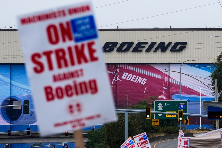 Boeing workers wave picket signs as they strike after union members voted to reject a contract offer, Sunday, Sept. 15, 2024, near the company's factory in Everett, Wash. (AP Photo/Lindsey Wasson)