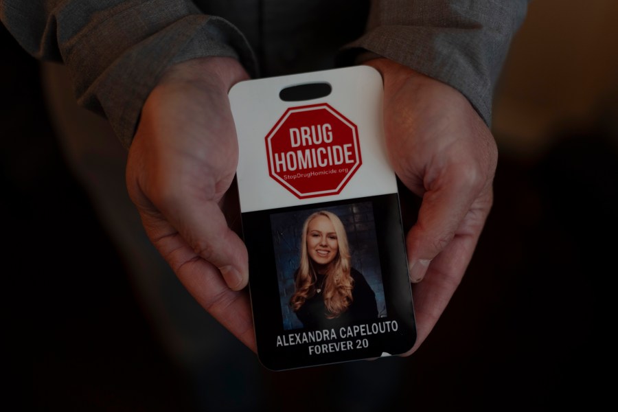 Matt Capelouto, whose daughter, Alexandra, died from a fentanyl overdose, holds an awareness card advocating for legal action against those responsible for drug-related deaths in Temecula, Calif., Tuesday, Sept. 17, 2024. (AP Photo/Jae C. Hong)