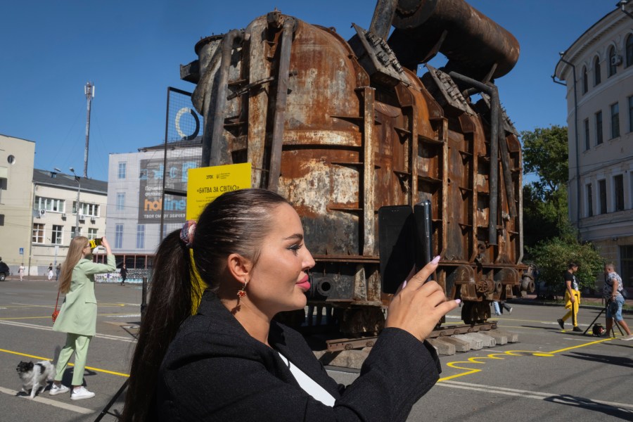 People take photos of a burnt transformer from one of power plants badly damaged in one of Russia's recent missile attacks on energy system in Kyiv, Ukraine, Thursday, Sept. 19, 2024. (AP Photo/Efrem Lukatsky)