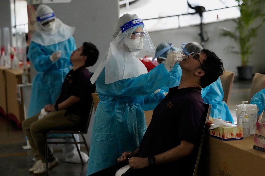 FILE - Shopping mall workers undergo a COVID-19 swab test during the opening at the Paragon shopping mall in Bangkok, Thailand, Wednesday, Sept. 1, 2021. (AP Photo/Sakchai Lalit, File)