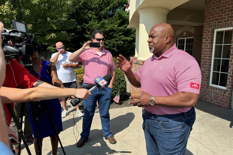 North Carolina Republican gubernatorial candidate Mark Robinson, right, speaks with reporters outside the Olympic Family Restaurant in Colfax, N.C., where Robinson held a campaign event on Monday, Aug. 26, 2024. (AP Photo/Gary D. Robertson)