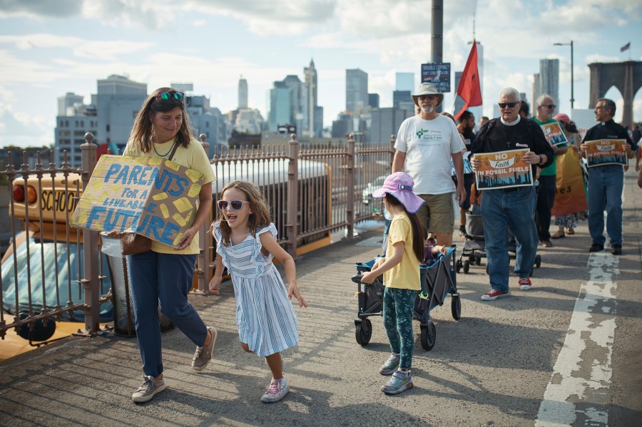 Protesters cross the Brooklyn Bridge during a Youth Climate Strike march to demand an end to the era of fossil fuels, Friday, Sept. 20, 2024, in New York. (AP Photo/Andres Kudacki)